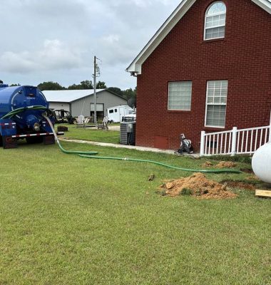 A large blue water tank is being used to clean debris from a yard, showcasing a yard maintenance activity.